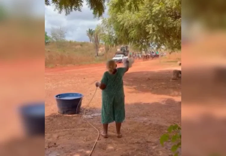 Moradora oferece água a cavalos durante cavalgada sob forte calor no Tocantins